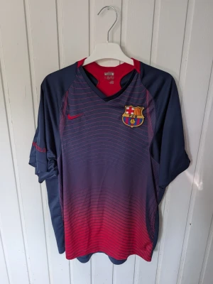 Barça matchtröja Nike blå/röd S - Snygg FC Barcelona matchtröja från Nike i blått och rött med klubbmärke på bröstet och diskreta ränder. Tillverkad i lätt och ventilerande material med Nike Dri-FIT-teknologi. Perfekt för fotbollsträning eller att bära som supporter.