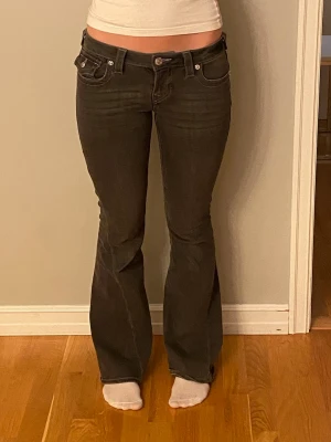 Bootcut mörkgrå jeans från true religion  - Snygga mörkgrå Lågmidjade jeans från true religion, aldrig använda och är i modellen joey och storlek w26