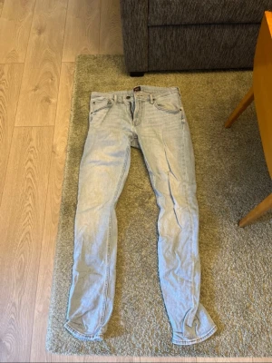 Ljusblå raka jeans från Lee - Säljer ett par ljusblå jeans från Lee med klassisk femficksdesign och rak passform. Jeansen har en Lee-lapp bak i midjan och är tillverkade i bomull. Perfekta för en avslappnad och trendig look. Använd 1 tillfälle.