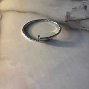 Silverfärgat armband  - Stilrent armband i silverfärg med unik spikformad design. Armbandet har en minimalistisk look med små glittrande detaljer på toppen av spiken som ger extra bling. Perfekt för dig som gillar edgy och modern stil.