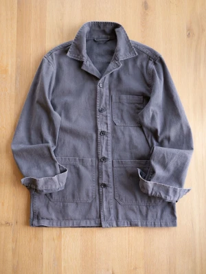 Mörkgrå Chore Jacket med fickor - Stilren mörkgrå overshirt i kraftigt bomullstyg med klassisk krage och knäppning framtill. Tre praktiska fickor framtill, varav en på bröstet. Perfekt lager-på-lager-plagg med avslappnad passform och uppvikta ärmslut.