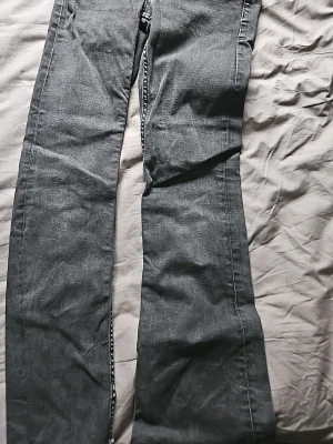 Mörkgrå bootcut jeans gina tricot - Snygga mörkgrå jeans med bootcut passform och klassiska fem fickor. Jeansen har kontrastsömmar och är tillverkade i ett denimtyg som ger en avslappnad look. Perfekta för dig som gillar en retrostil med utsvängda ben. Storlek 158