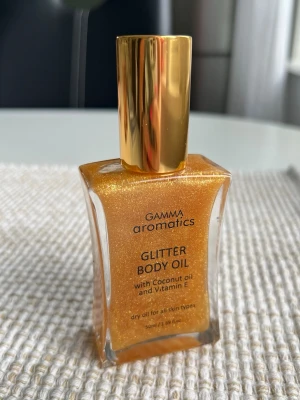Glittrig guldig body oil - En guld-glittrig body oil. Perfekt för sommarfesten eller utlandsresan!   Aldrig använd.