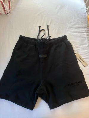 Svarta Essentials shorts - •Skick: 10/10, helt ny • Storlek: L • normal i storlek. (öppen för bud 💬)  Skicka DM för fler bilder eller info! 🫱🏾‍🫲🏽
