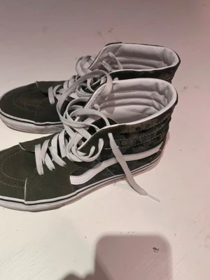 Camouflage gröna Vans  - Säljer min vans då dom inte använts längre. Storlek 41. Min hund har tuggat sönder ena sko snöret (se sista bild). Men annars i topp skick. Man kan ju alltid byta ut skosnöret om man stör sig på det.