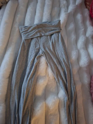 Grå höga leggings med bred linning - Säljer ett par mjuka och stretchiga grå leggings med låg midja  och bred linning. Från kappahl i storlek 158 Perfekta för en chill och avslappnad stil. Materialet känns skönt mot huden och passformen är tight hela vägen ner.