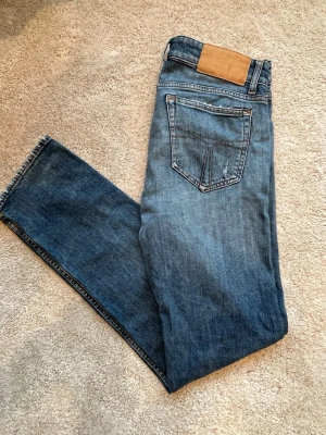 Tiger of Sweden jeans  - Säljer ett par blå jeans med snygga slitningar. Perfekta för en avslappnad och trendig look.