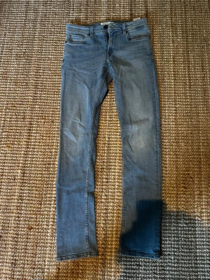 Blå skinny jeans från Stock & Hank - Snygga blå skinny jeans från Stock & Hank med klassisk femficksdesign och ljus tvätt. Jeansen har normal midja och raka ben, tillverkade i stretchigt denim för extra komfort. Perfekta för en avslappnad och trendig look. ❗️W29 L32❗️
