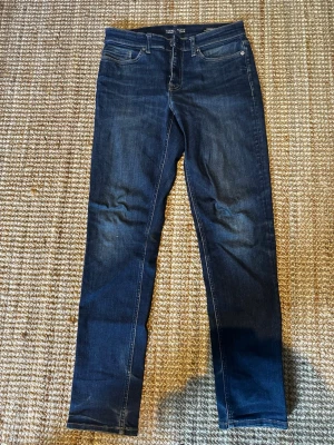 Mörkblå slim jeans med stretch - Snygga mörkblå slim fit jeans med stretchteknologi för extra komfort. Klassisk femficksmodell och smal passform som sitter tajt längs benen. Perfekta för dig som gillar en modern och stilren look.