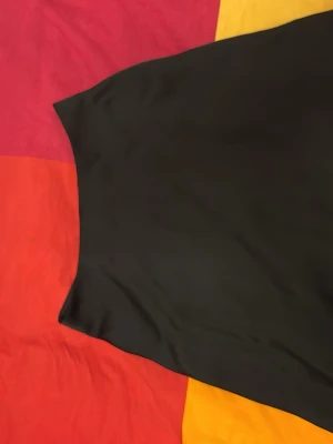 Svart A-linjeformad kjol - Säljer en svart, enkel och stilren A-linjeformad kjol i ett mjukt och lätt material. Kjolen har en diskret dragkedja bak och passar perfekt till många olika looks. Lätt att matcha och superbekväm.