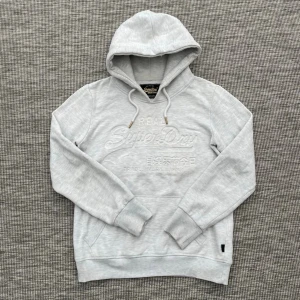 Superdry hoodie - Säljer nu denna riktigt snygga superdry hoodien!🙌 Skick: 8/10⭐️ Storlek: Eu 40👏 - Ungifär som en XS🤩 Hör gärna av er vid frågor eller funderingar🤗
