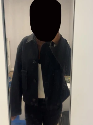 svart kappa  - Säljer en svart kappa som har stora knappar framtill och en klassisk krage. Perfekt för dig som gillar en enkel men stilren look.