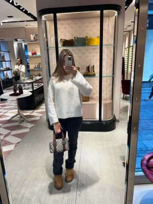 Vit oversized stickad tröja - Säljer en vit, oversized stickad tröja med rund hals och långa ärmar. Tröjan har en enkel och clean design, perfekt att styla med jeans eller kjol. Materialet ser mjukt och fluffigt ut, vilket gör den extra mysig under kyliga dagar.