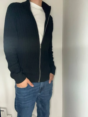 Helt ny fullzip från Lindbergh - Detta är en helt ny fullzip från Lindbergh! Färgen på tröjan är svart. Som ni kan se på bild 4 är tröjan helt ny med prislappen kvar. Nypris 899 kr! Tröjan är i storlek M och har en skön passform. Som sagt så är tröjan i helt nytt skick och inte använd! Har du frågor? Fråga! Pris ej ristat i sten.