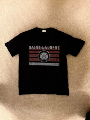Saint Laurent T-shirt  - Snygg svart saint-Laurent T-shirt i riktigt bra skick. Inga tecken på användning och inga defekter. Hör av dig vid fundering av tröjan eller prisförslag!