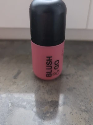 Blush & Go flytande rouge rosa - Blush & Go är ett flytande rouge i en smidig flaska med svart lock. Färgen är en mjuk rosa nyans, perfekt för att ge kinderna en fräsch look. Produkten heter '02 On The Go' och är tillverkad i Italien. Enkel att applicera och ta med sig.