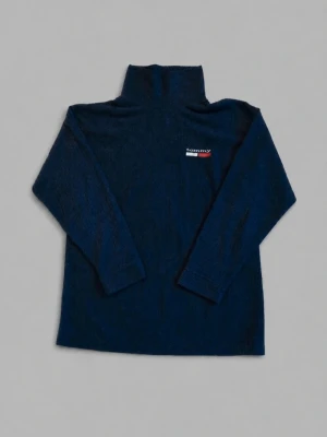 Mörkblå polotröja ribbad fleece Tommy Hilfiger Y2K - Mörkblå ribbad polotröja från Tommy Hilfiger med broderad logga på bröstet. Tröjan har lång ärm och hög krage, perfekt för lager på lager och en clean look. 