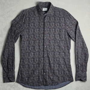 Stenströms Slimline brun mönstrad skjorta storlek M - Elegant mönstrad skjorta från Stenströms med diskreta jordnära toner och exklusiv känsla. Perfekt både till dressade tillfällen och smart casual med jeans eller chinos.  Storlek/passform Storlek M Slimline passform  Skick Mycket fint skick.  Mått Bröstbredd: ca 47 cm Plagglängd: ca 74 cm Axelbredd: ca 43 cm Armlängd: ca 69 cm  Tycker du priset är för högt? Skicka ett prisförslag!
