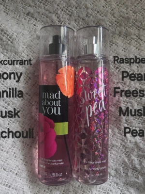 Bath & Body Works body mists duo - Två body mists från Bath & Body Works: 'Mad About You' med blommigt motiv och 'Sweet Pea' i rosa flaska med glittrigt mönster. Båda flaskorna är genomskinliga med sprayfunktion och rymmer 236 ml vardera.