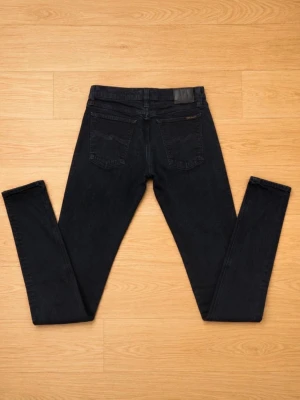 Mörkblå slim fit jeans W33 L34 - Snygga mörkblå jeans i slim fit-modell med klassisk femficksdesign och raka ben. Jeansen har knappgylf och är tillverkade i ett mjukt denimtyg som sitter skönt. Perfekta för dig som gillar en enkel och stilren look. Inget slitage