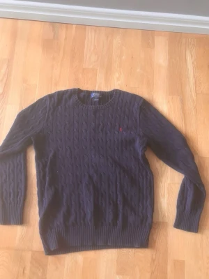 Polo Ralph Lauren kabelstickad - Snygg mörkblå kabelstickad tröja från Polo Ralph som passar dig som är över 186cm. 
