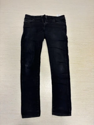 Svarta super skinny jeans FSBN - Svarta jeans från FSBN i super skinny-modell. Jeansen har klassisk femficksdesign, låg midja och smala ben. Perfekta för dig som gillar en tight passform och stilren look. Tillverkade i ett stretchigt material för extra komfort.