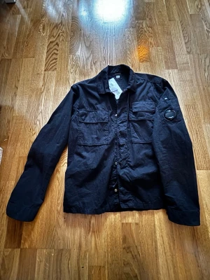 C.P. Company overshirt - Cp company Gabardine over shirt storlek S. Endast testad, sen bara hängt i garderoben. Lapparna finns kvar, köpte på debut för 3599kr öppen för prisförslag.