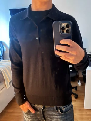 Sweater Uniqlo  - Snygg svart stickad tröja från uniqlo med klassisk krage och knappdetalj framtill. 