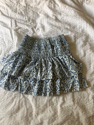 Blåvit volangkjol  - Kjol med två volanger och smilad midja. Med ett blåvitt mönster från meet me there storlek s/m med inbyggda shorts.