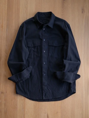 Svart overshirt i bomull, size M - Overshirt i svart bomull med klassisk krage, knäppning framtill och två stora bröstfickor med lock. Långa ärmar med manschetter och rak passform ger en clean och enkel look.