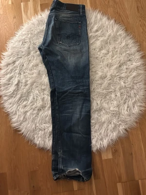 Blå  replay jeans med slitningar o raka ben - Säljer ett par blå replay jeans med raka ben och slitningar. Jeansen har klassisk femficksdesign och en mörk tvätt med snygga slitningar. Materialet är denim och passformen är rak. Perfekta för en avslappnad och trendig look. Sitter något mindre än w33 mer som w32 