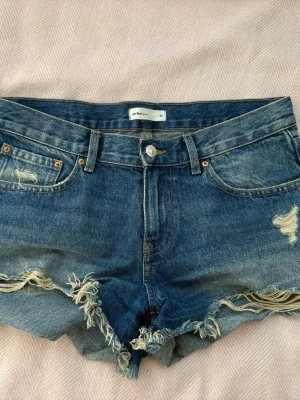 Lågmidjade shorts - Lågmidjade shorts från Gina tricot, men skulle nog säga att dom är mer mid waist på mig iallafall :) lite missfärgade vid slitningarna på låren