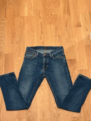 Nudie Grim Tim - Säljer dessa stilrena blåa nudies i storlek L30 W30. Dem är nyligen reparerade och tvättade  hos nudie så dem är helt fel fria. Priset är ej hugget i sten! 