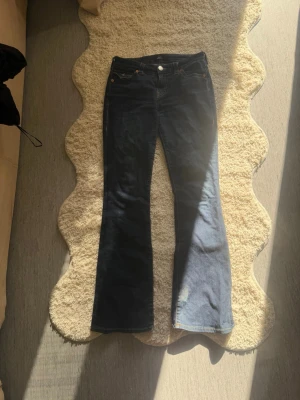 True religion jeans  - Ett par mörkblåa true religion jeans i ändå acceptabelt skick, de ända defekterna är nere vid fötterna då de blivit lite trampade på.. pris går att diskuteras, hör av dig om du har fler frågor.