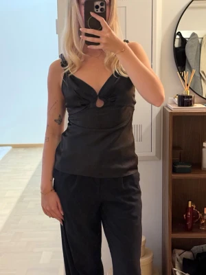 Supersöt satinlinnetopp från adoore🌸 - Supersöt topp i satin från adoore, toppen har smala axelband och en liten ringdetalj framtill, säljs inte längre. Perfekt att styla med både jeans och kjol för en trendig look. Toppen är aldrig använd och har alla lappar kvar. Nypris ca 1000kr🌸💅🏽