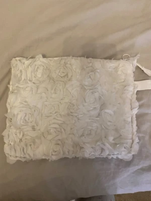 Datorfodral ipadfodral necessär  - Säljer en UNIK vit datorväska med 3D-blommor i tyg. Går jättebra att tvätta.  Väskan har dragkedja på sidan, perfekt för laptop eller surfplatta eller bara som en necessär. Väldigt vadderat och skyddar därför ordentligt! Materialet är mjukt tyg med dekorativa rosor över hela framsidan. Obs sista bild ser man att lite av tyget är borta. 