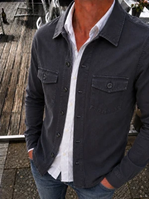 Ciszere Overshirt svart – Slim Fit Utility Skjorta - Snygg Ciszere overshirt i mörkgrå/svart nyans med subtil textur och klassisk utility-design. Modellen har två bröstfickor med knappar, klassisk krage och knappstängning framtill. Tillverkad i 97% bomull och 3% elastan för en bekväm och följsam passform. Slim fit-look. Storlek S.