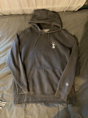 Grå Stüssy hoodie  - Säljer en grå hoodie från Stüssy med stor vit logga och text på ryggen samt mindre tryck på bröstet och ärmen. Storlek L. 