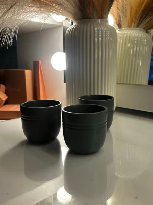 Tre svarta små keramik krukor - Säljer tre stilrena svarta keramikkrukor med rund form och två diskreta linjer runt om. Perfekta för små växter. Snygg minimalistisk design som passar i de flesta hem. Färgen är lite ljusare i verkligheten 