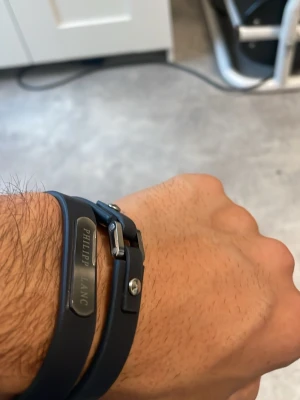 Svart läderarmband Philipp Lang - Snyggt svart armband i läder från Philipp Lang med metallspänne och dekorativ metallplatta med ingraverad logga. Armbandet har dubbla remmar och justerbar passform med nitar. Perfekt accessoar för en stilren look.