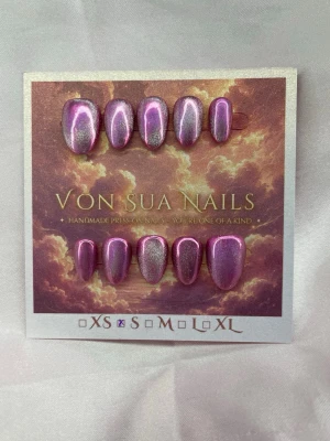 LilacAura (S);ExtraShortAlmond  - Handgjorda unika press-on naglar i en skimrande lila metallic, med cateye. Naglarna har en extra kort mandelform och en glansig finish som verkligen sticker ut. Perfekt för dig som vill ha ett unikt och snyggt nagelset utan att behöva gå till salong.S: 15 mm, 11,5 mm, 12 mm, 11 mm, 9 mm 