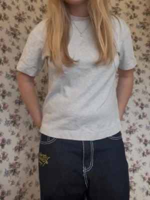 Ljusgrå basic t-shirt - En enkel och stilren ljusgrå t-shirt med normal passform och korta ärmar. Tillverkad i mjuk bomull som känns skön mot huden, något tjockare i tyget. Perfekt att matcha med jeans eller shorts för en clean look.❣️