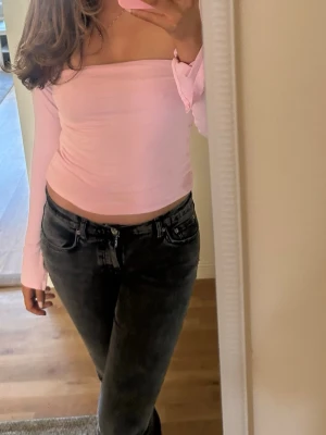 Ljusrosa offshoulder topp - Trendig ljusrosa offshoulder topp med långa ärmar och croppad passform. Se defekt på bild