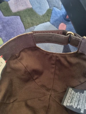 Beige Gucci keps  - Säljer en beige Gucci keps som va köpt för några år sedan men har bara varit använd under ungefär 3 veckors tid, den e självklart äkta och man får med alla påsar och lådor när man köper! STORLEK S/56cm