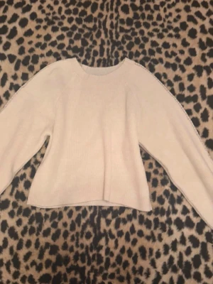 Beige stickad tröja med spetsdetalj - Säljer en vit stickad tröja med rund hals och långa ärmar. Tröjan har en snygg spetsdetalj längs ärmarna som ger en extra touch. Passar perfekt till jeans eller kjol.