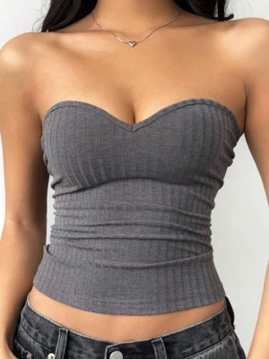 Grå topp - Snygg grå bandeau tubtopp med ribbad struktur och hjärtformad urringning. Säljer då den inte kommit till använd den jag köpt den, den är i nytt skick.