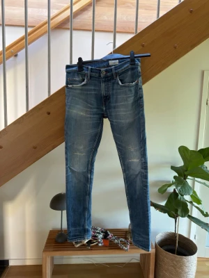 Limiterade Tiger Sweden jeans med fet tvätt  - Säljer ett par blå slim fit jeans med snygga slitningar och tvättade detaljer. Jeansen har klassisk femficksdesign, normalhög midja och smala ben. Perfekta till en avslappnad stil och passar till det mesta i garderoben. slitningarna ska vara där bvsa 