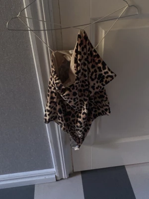 Leopardmönstrad body - Säljer en snygg body med leopardmönster i beige, brunt och svart. Klassisk modell med tunna axelband och hel rygg. Perfekt för dig som gillar leopardmönster. Materialet är stretchigt och följsamt.