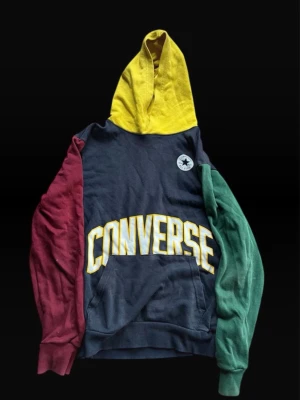 Flerfärgad hoodie från Converse - Säljer en riktigt snygg hoodie från Converse med stor gul logga på bröstet. Tröjan har gul huva, marinblå kropp, vinröd ärm och grön ärm. Klassisk känguruficka framtill och Converse-märke på bröstet. Perfekt för dig som gillar färg och streetwear. Rare find skate vibe 