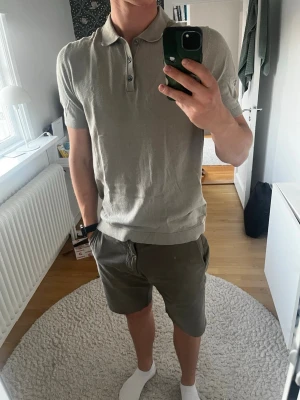 Beige polotopp från Jack & Jones - Säljer en stilren beige polotopp från Jack & Jones med korta ärmar och klassisk krage. Toppen har knappar framtill och är tillverkad i mjuk bomull, perfekt för en clean och avslappnad look. Knappt använt den!